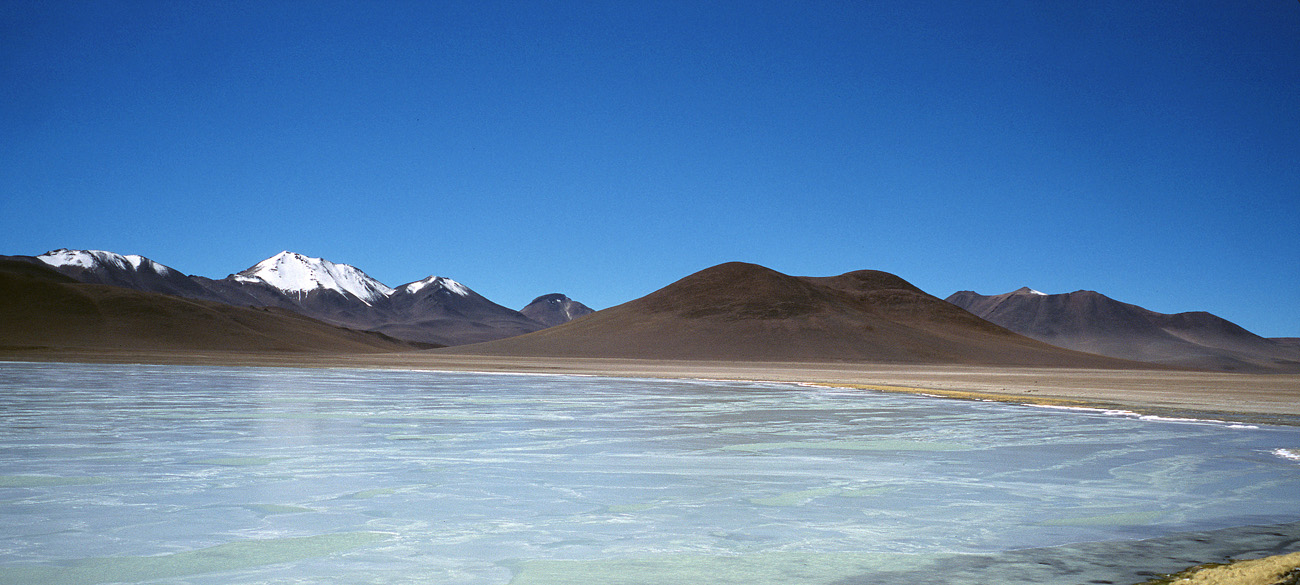 chi_7_33 laguna_bianca pano.jpg - Sud Lipez laguna Blanca la surface tantôt bleue tantôt verte est due aux surfaces ici et là encore gelées de la lagune